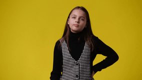 4k video of one girl touching with her hair and thinking about something over yellow background.