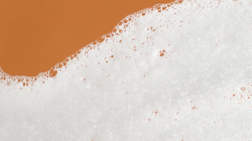 Soap foam moving in orange background, natural shampoo white bubbles motion, slow motion, 8K downscale, 4K. Royalty-Free Stock Footage #1105255757