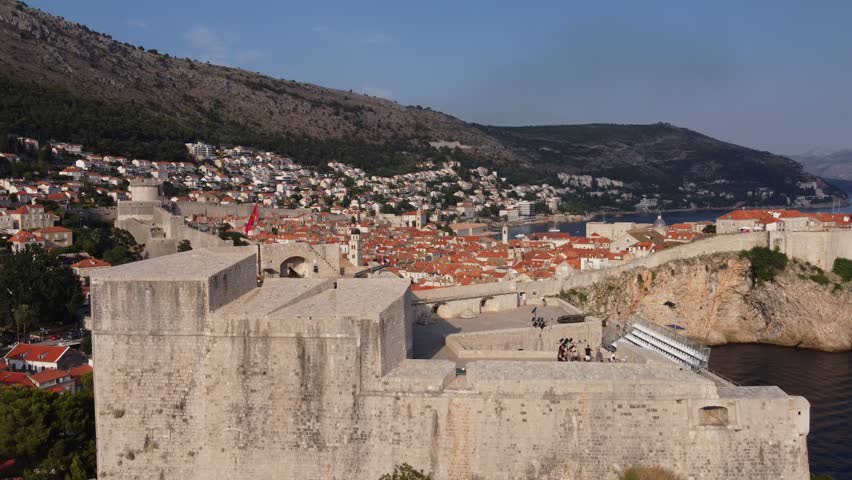 Tourists taking a guided Tour on Fort Lovrijenac against city walls of old town - King