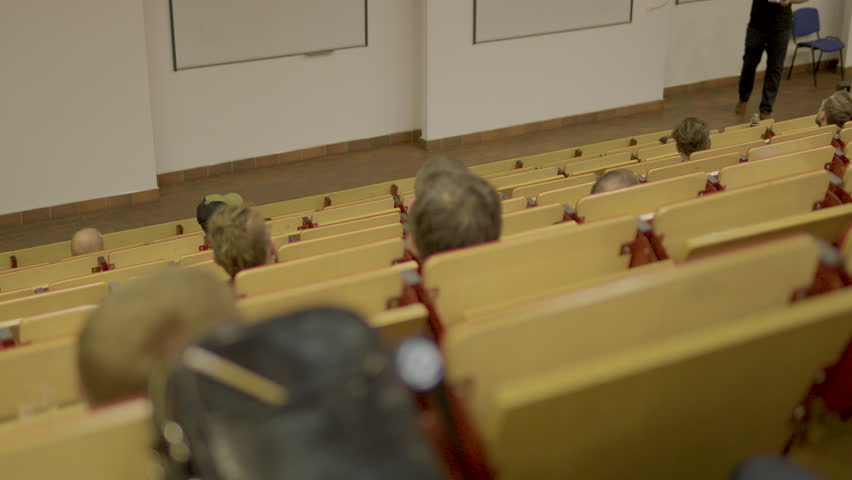 Group Of University Students Sitting At Their Desks In Auditorium And Listening - Slow Motion shot