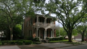 Historic home with iron fence and old Southern Live Oak trees in downtown Mobile, Alabama with gimbal video walking forward at an angle.