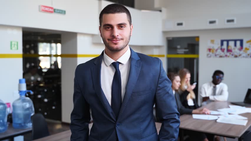 Smiling arab businesman in formal outfit looking at camera standing in office. Portrait of happy handsome multiethnic man wearing suit, bow tie. Confident corporate worker posing.