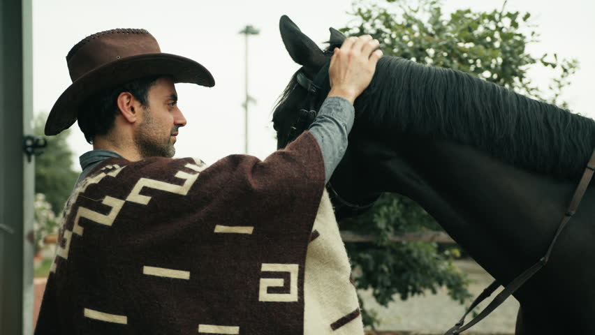 Legend cowboy with hat caress the horse
