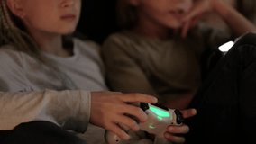 boy and girl playing video game console using joystick or controller while sitting at home, Two children small caucasian brother and sister happy children siblings, real people family leisure concept.