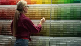 Woman looking at paint chips in a hardware store. Concept of home remodeling shopping experience. - Powered by Shutterstock - Get 15% off with code: PIKWIZARD15