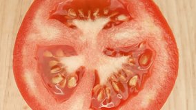 The viewer can observe the delicate veins that run across the tomato's flesh, the minute hairs on its skin, and the small imperfections that add to its natural beauty. Macro footage. Tomato background