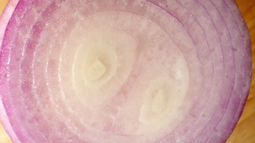Captivating macro video showcases the intricate beauty of half red onions through a mesmerizing probe lens. Delve into the stunning details of nature's artistry. Red onions background
