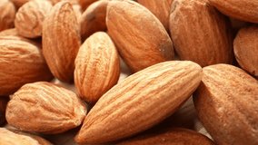 Captivating macro video of almond kernels: Magnifying their elegant contours, intricate crevices, and radiant amber shade, showcasing the exquisite craftsmanship of nature. Almond kernels background.
