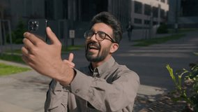 Arabian businessman smile talk video call use mobile phone technology business communication outdoors in sunny city happy guy Indian man employer leader entrepreneur talking distant happy greet online - Powered by Shutterstock - Get 15% off with code: PIKWIZARD15