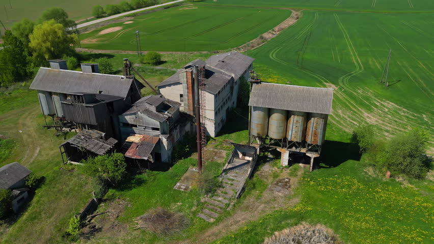Farming Equipment In Roof Houses Stands On A Large Agriculture Field. pull-back