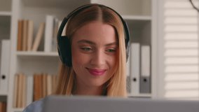 Caucasian woman business girl distant student internet teacher video call conference class lesson e-learning virtual meeting nod head yes positive answer listen music headphones with laptop in office