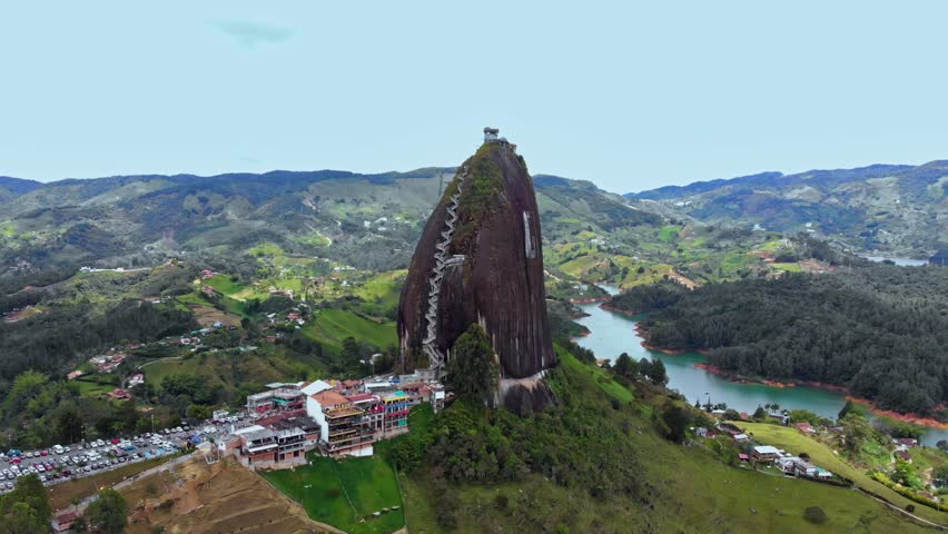 Aerial around El Peñón de Guatapé, a large and unique stand alone rock with stairs to the top and featuring panoramic views, Guatapé, Colombia. Drone slow orbit shot