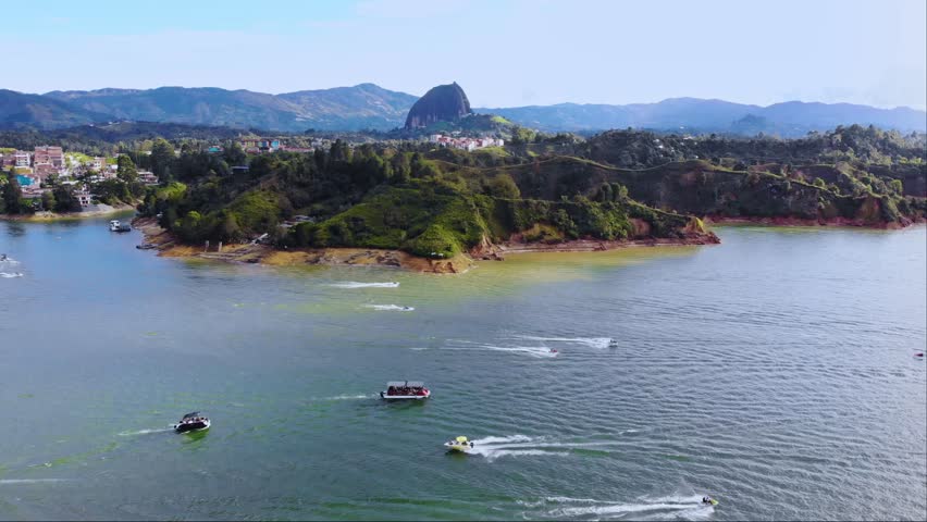 Aerial near El Peñón de Guatapé, a large and unique stand alone rock with stairs to the top and featuring panoramic views, Guatapé, Colombia. Drone static shot
