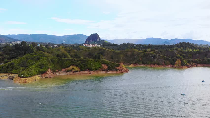 Aerial near El Peñón de Guatapé, a large and unique stand alone rock with stairs to the top and featuring panoramic views, Guatapé, Colombia. Drone dolly forward