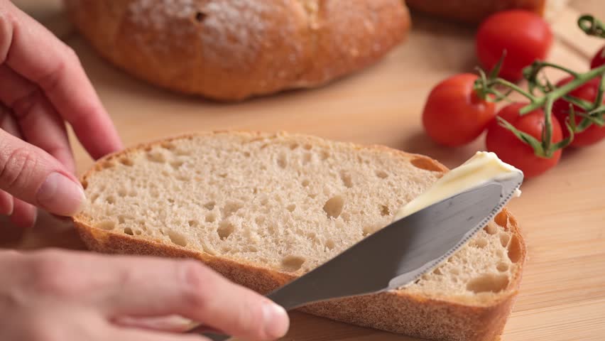 Woman spreading soft butter on slice of bread. Spreading cream cheese on bread. Housewife making sandwich for breakfast. Royalty-Free Stock Footage #1105290779