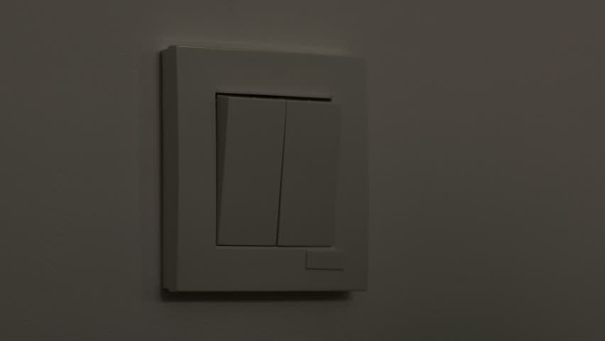 Man turning on light in the room with double switch on the wall. Turning on light, artificial light source in dark room Royalty-Free Stock Footage #1105291435