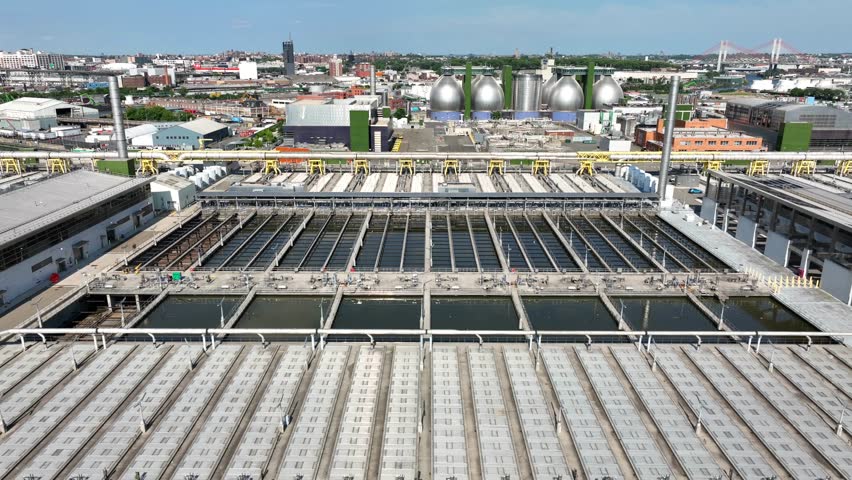 Large water sanitation and wastewater treatment plant in NYC. Brooklyn Newtown Creek Plant is the largest sewage treatment facility operated in New York City. Aerial truck shot. Royalty-Free Stock Footage #1105291957