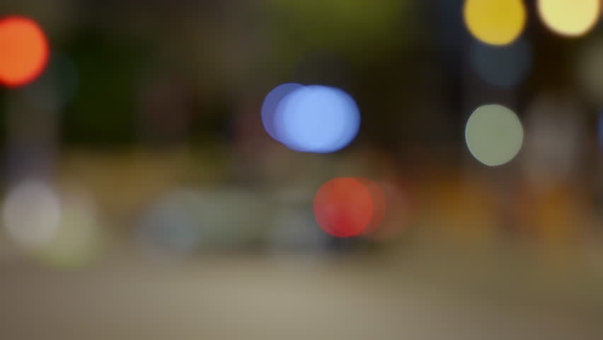 Blurry lights with police patrol car siren flashing red and blue lights in city street at night. Bokeh out of focus background. Crime scene or closed emergency zone in urban area. City lights circles Royalty-Free Stock Footage #1105300003