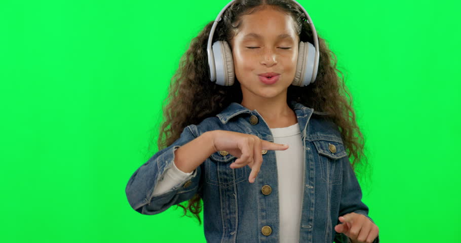 Green screen, headphones and girl dance, music and singing on kids radio, podcast and excited or talent. Celebrate and happy child listening, streaming or audio electronics and studio background