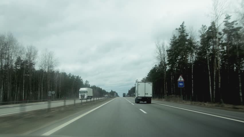 view from the windshield of a car on a motorway with traffic from cars. Gray cloudy weather, background. Copy space for text