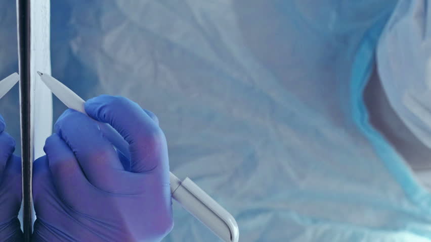 Vertical video. Disease history. Medical assessment. Coronavirus pandemic. Doctor in protective equipment writing report with hands in blue medical rubber gloves. Royalty-Free Stock Footage #1105306555