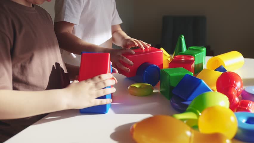 kindergarten close-up. a group of children play toys cubes and cars on the table in kindergarten. happy family preschool education concept. nursery boy baby toddler home indoor Royalty-Free Stock Footage #1105307439