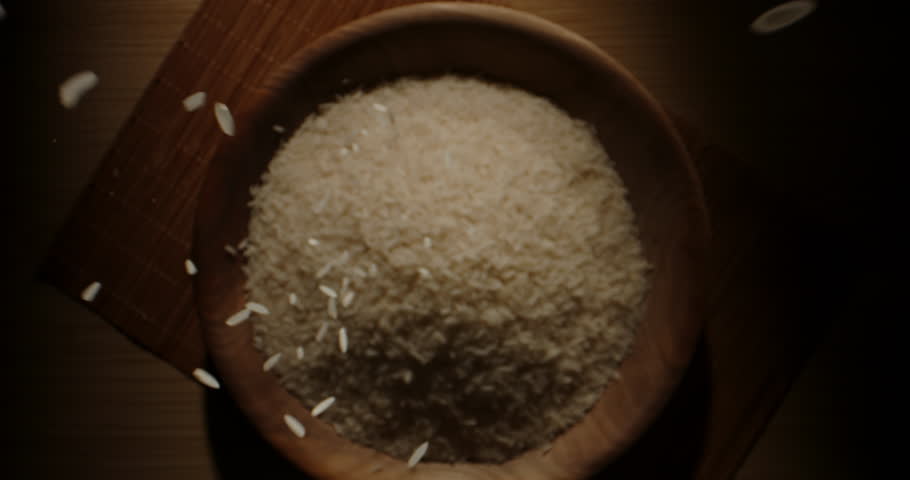 Falling Rice wooden bowl cup. Top view slow motion zoom in. Asian Indian Japanese food culture groats cereals sushi sashimi. Concept healthy nutrition morning routine. Scattering rice nourishment Royalty-Free Stock Footage #1105309623