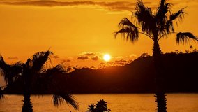 Beautiful sunset with mountains and palms in Oludeniz in Turkey. 4k time lapse video footage UHD 3840x2160