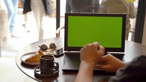 Morning coffee and fresh news from the internet. Green chromakey screen. Man using scrolling social media typing laptop, freelancer remote working place. Video footage template.  Sun glasses 