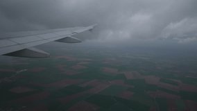 First-person view through window on wing of plane passing through gloomy clouds during descent over Paris. View of jet airplane wing shaking from air turbulence while flying through dark storm clouds. - Powered by Shutterstock - Get 15% off with code: PIKWIZARD15