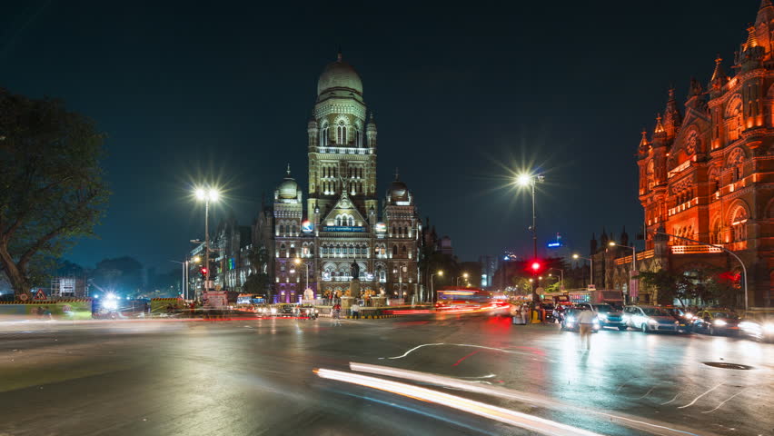 Timelapse view of traffic in front of historic landmarks BMC Building and Chhatrapati Shivaji Terminus (Victoria Station) at night in Mumbai, Maharashtra, India.  Royalty-Free Stock Footage #1105326431