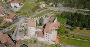 Aerial ascending top down view of Tenno Castle perched on rocky hillside in Trentino, northern Italy