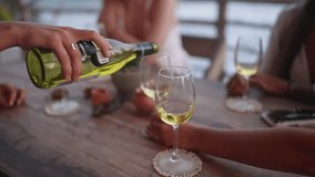 Woman fill glasses of her friends pouring white wine in sea view restaurant. Female hands hold bottle of alcohol drink celebrating birthday, New Year, hen party in bar close-up. Girls. 3D Illustration - Powered by Shutterstock - Get 15% off with code: PIKWIZARD15