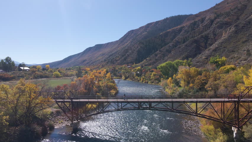 Aerial view of people crossing the Colorado River via the pedestrian walkway as the river rushes below in Glenwood Springs, Colorado.