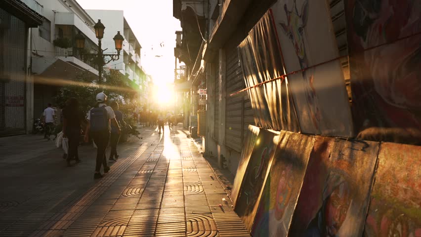 Dominican Republic, Santo Domingo - April 23, 2023: Sunset on El Conde pedestrian street, people walk and buying souvenir paintings in Colonial City