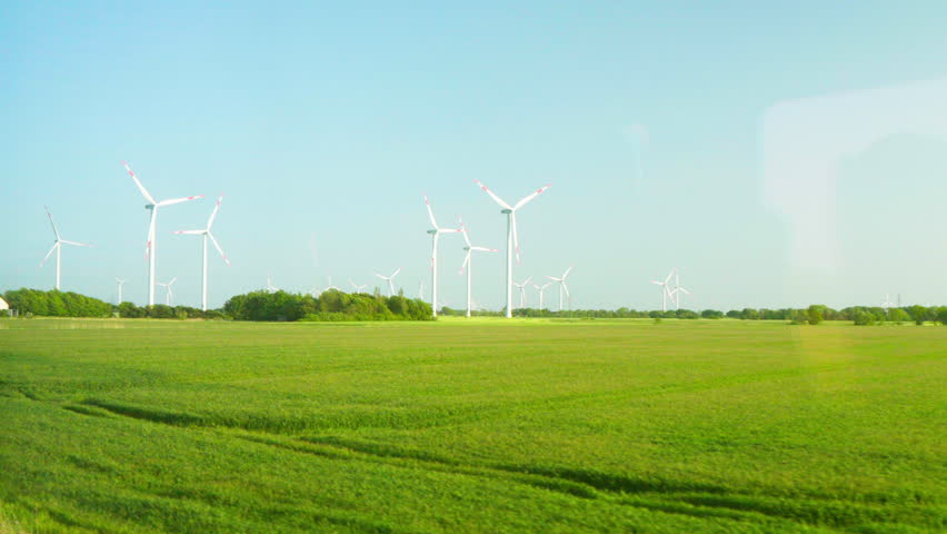 Panoramic View of Wind Turbines on Green Fields in Northern Germany. Train window view. Slow Motion. Royalty-Free Stock Footage #1105341505