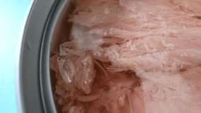 Delve into the captivating world of canned tuna through a macro video: witness its shimmering scales, tender flesh, and rich hues, a feast for the eyes that promises a delightful culinary journey.

