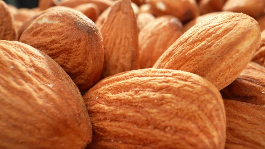 In a macro video of almond kernels, the intricate details and textures of the almonds are captured in stunning close-up shots. Food and snack concepts. Almond kernels background. 4K HDR

