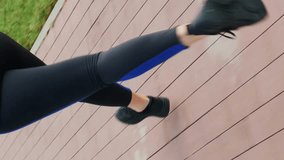 Young chubby female jogging on street, close up of legs. Vertical video. Sportive woman in leggings and sneakers running in city park at sunset. Fitness activity. Cardio workout exercises