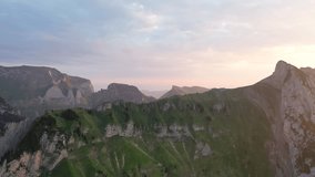 4K drone footage of a green mountain ridge in the Swiss Alps on an epic sunset during the golden hour.