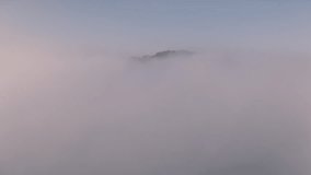 Drone video flying above the fog and clouds to the top of the fog beautiful scenery sea fog and high mountains