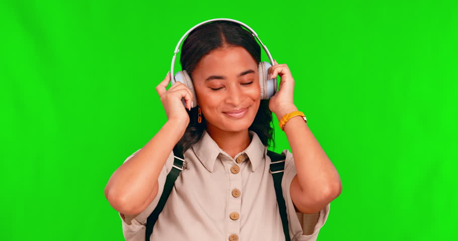 Music, headphones and woman dance in green screen studio to podcast or audio on mockup background. Radio, earphones and female person happy with streaming, subscription or dancing playlist or track