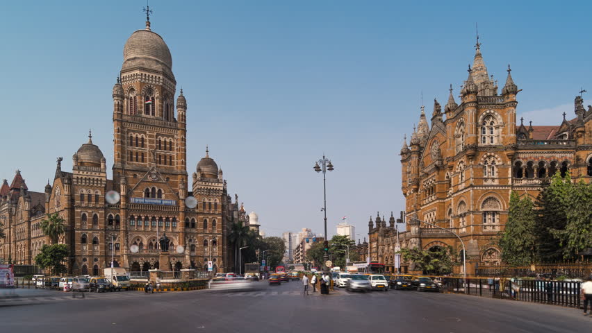 Timelapse view of traffic in front of historic landmarks BMC Building and  Chhatrapati Shivaji Terminus (Victoria Station) in Mumbai, Maharashtra, India, zoom out.  Royalty-Free Stock Footage #1105355547