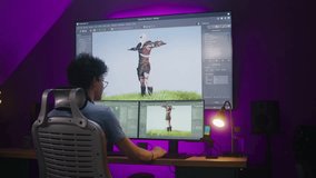 Young 3D designer draws video game character, creates animation, works remotely at home office. Computer and big digital screen with professional software interface for 3D modeling and design.