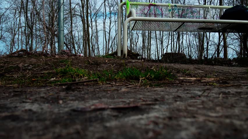 aerial ascent with view of a brown spring nature scene in a park and anarchy graffiti bench in Marzahn Hellersdorf Berlin