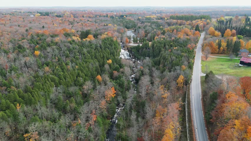 Aerial shot of a large Ontario forest on a fall day with a waterfall.