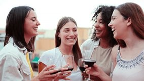 Group of happy young women friends having fun toasting wine glasses on a rooftop party, drinking and laughing together. Four cheerful girls smiling an clinking with drinks on a social reunion at bar - Powered by Shutterstock - Get 15% off with code: PIKWIZARD15