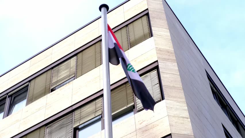 Frankfurt, Germany - May 25, 2022: silk national flag Algeria on facade building of Consulate General of iraq in Frankfurt, concept of immigration, international relations, tourist visa processing