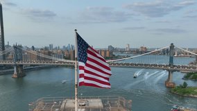 American flag waving proudly in front of Manhattan Bridge and downtown New York City. Aerial orbit of USA flag on Brooklyn Bridge. - Powered by Shutterstock - Get 15% off with code: PIKWIZARD15