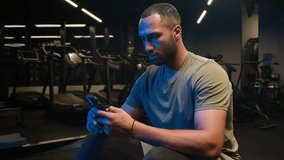 African American fitness man athlete personal trainer using smartphone sportsman browsing online messages mobile phone sharing workout photos on social media chatting online sport app service in gym - Powered by Shutterstock - Get 15% off with code: PIKWIZARD15